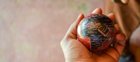 10 Swahili language quick facts, hand holding a ball with a world map centred on Africa.
