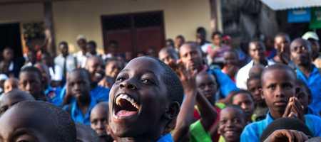 A large group of smiling Kenyan School Children.