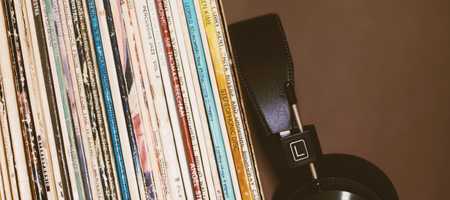 Headphones resting against books on a shelf.
