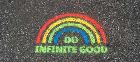 Rainbow painted on floor with "do infinite good" written underneath.